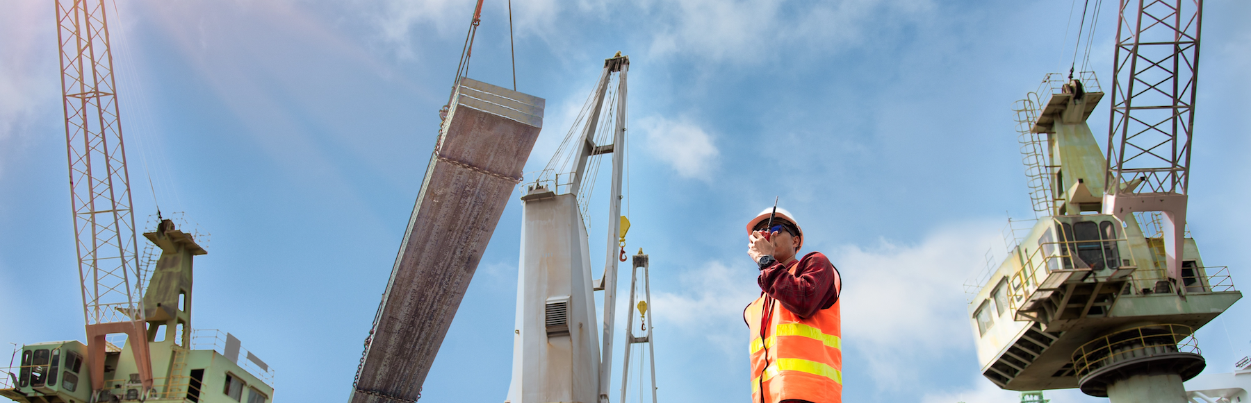 Man in safety vest communicating via radio at a construction site