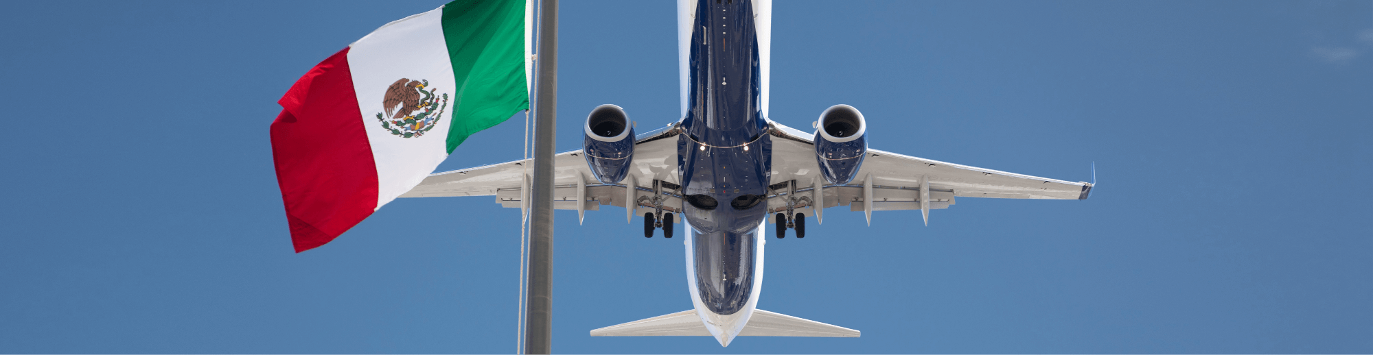 Plane flying over the flag of Mexico