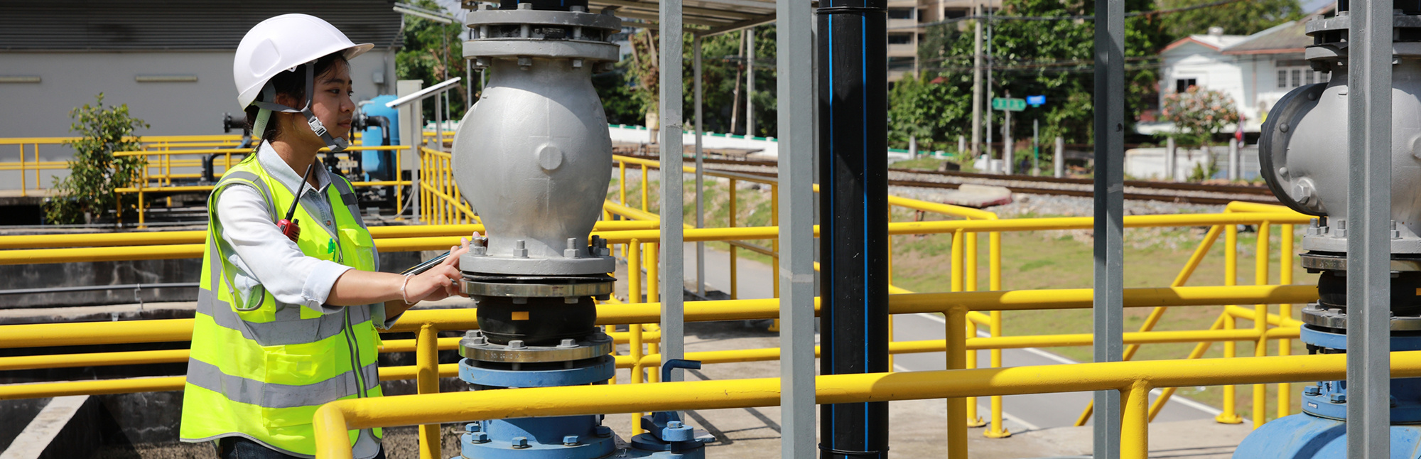 Woman in white hard hat working at a waterworks facility