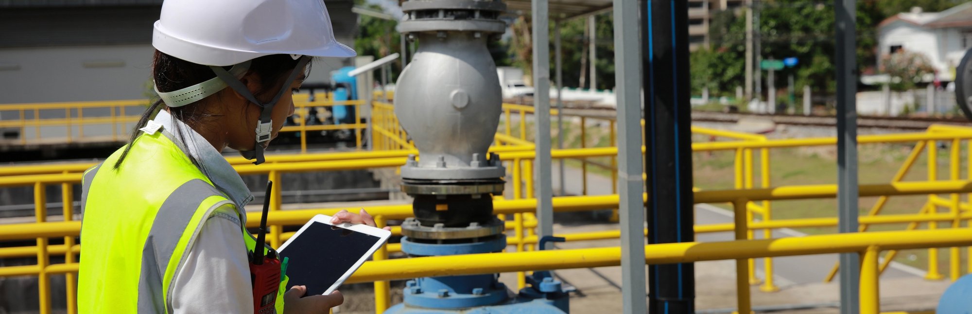 Woman walking outside at a waterworks facility with an iPad