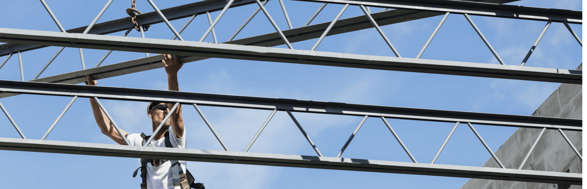A man is directing a steel beam into place