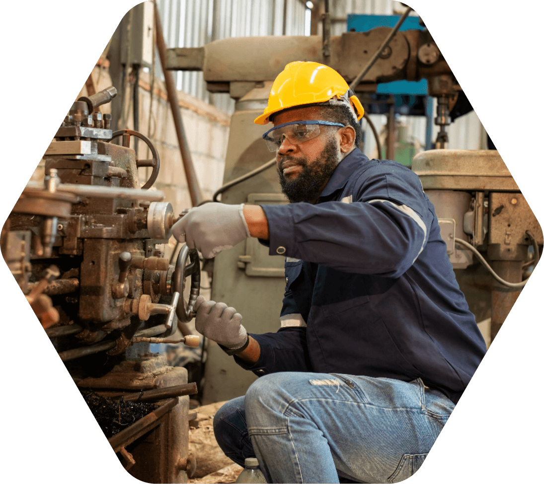 Man in yellow hard hat working inside a manufacturing facility