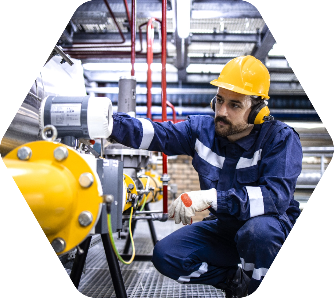 Man in yellow hard hat inspecting oil and gas equipment