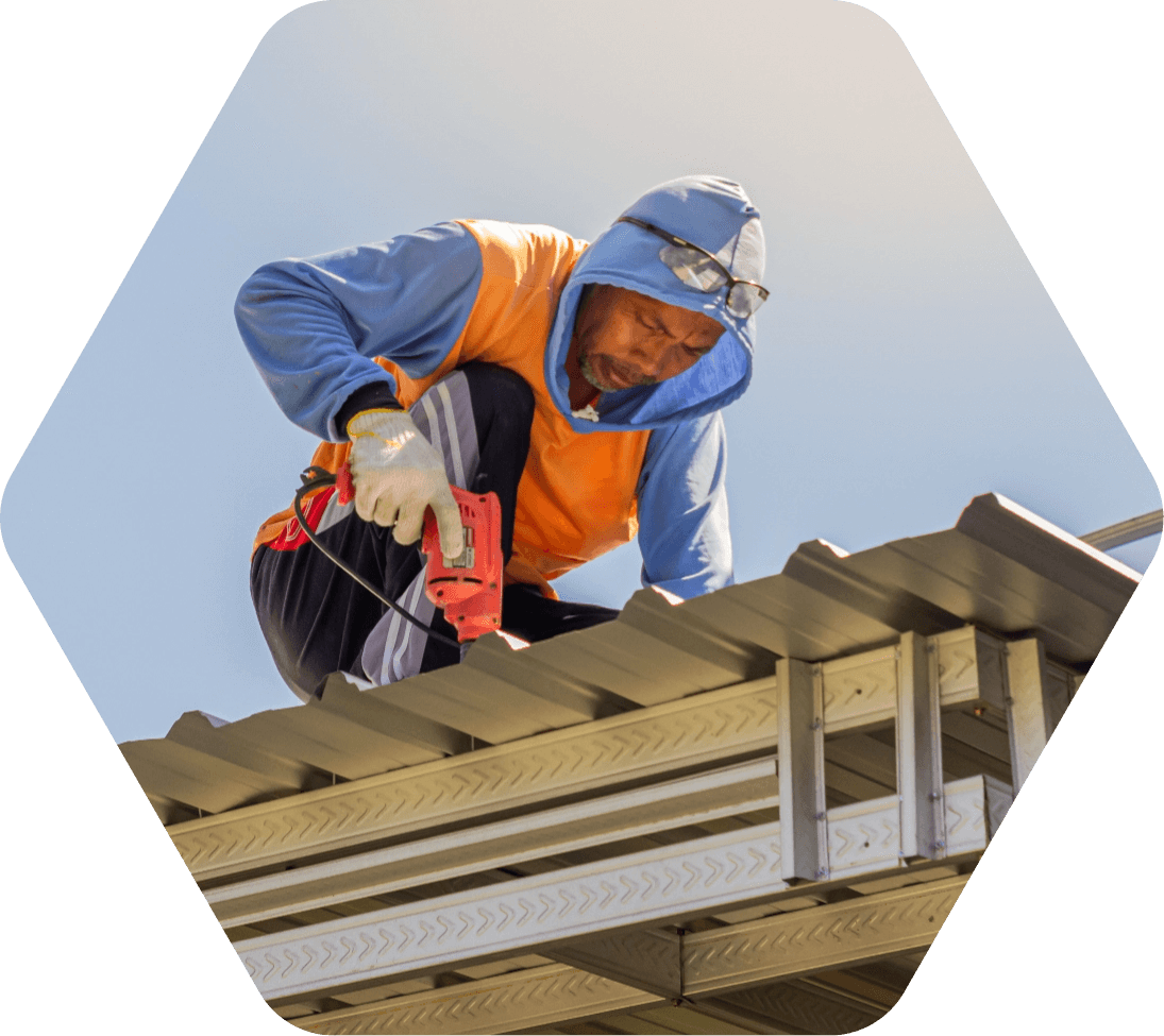 Man fastening screws to a metal building under construction