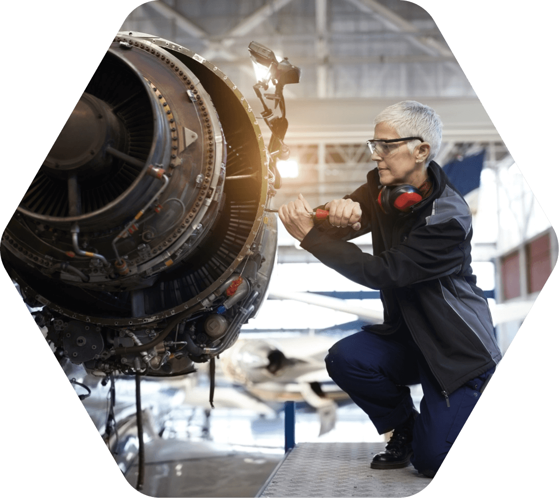 Woman tightening a bolt on an airplane engine