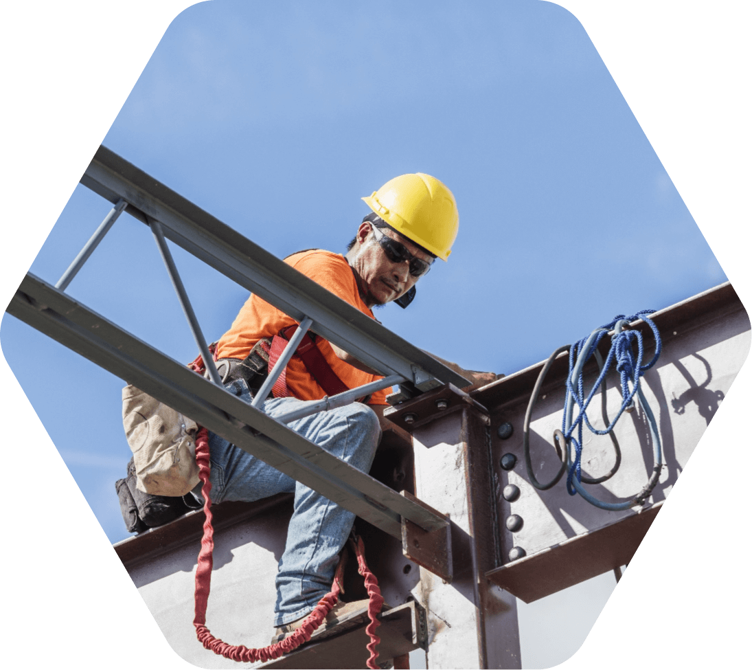 Construction worker in yellow hard hat working on a steel beam