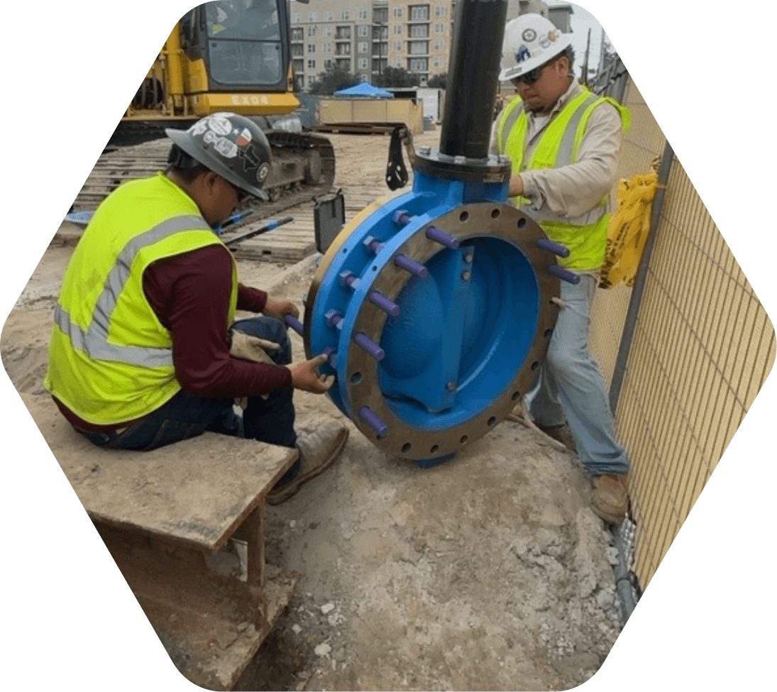 Two men in yellow safety vests checking bolts on equipment