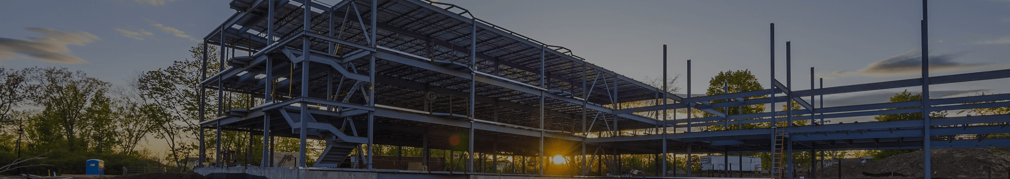 Building under construction as the sun sets in the background