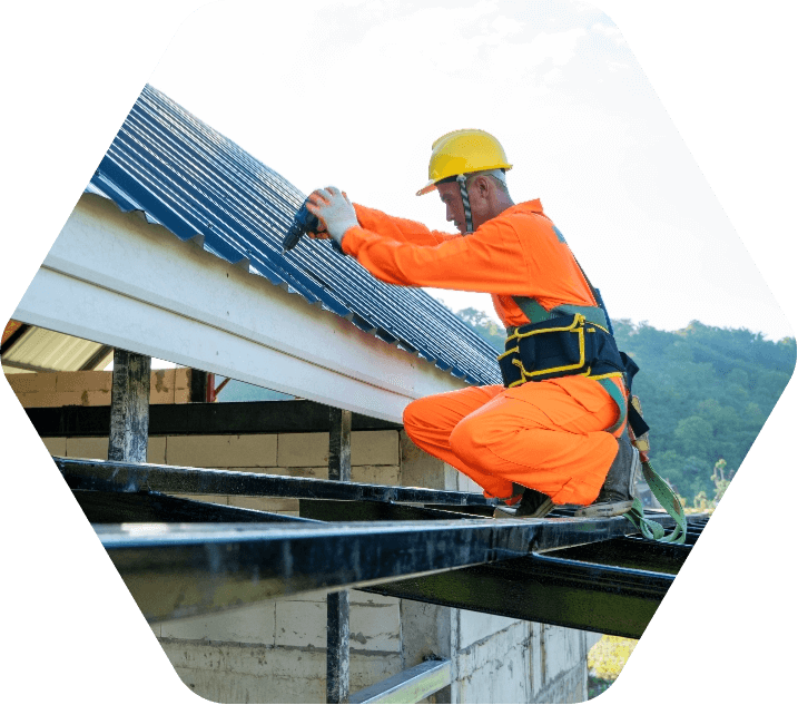 Man in yellow hard hat drilling into a roof