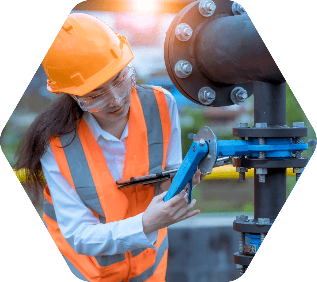 Woman in orange hard hat and safety vest securing a bolt