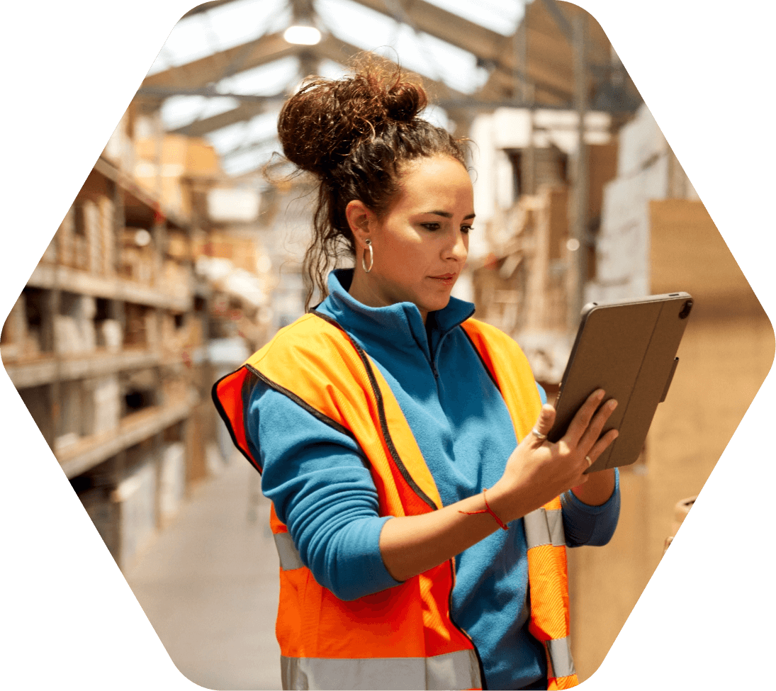 Woman checking inventory on a tablet inside an industrial distribution center