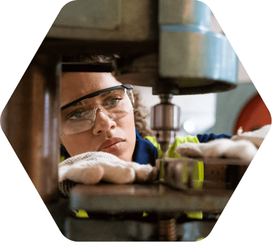 Woman in safety glasses working at a machine