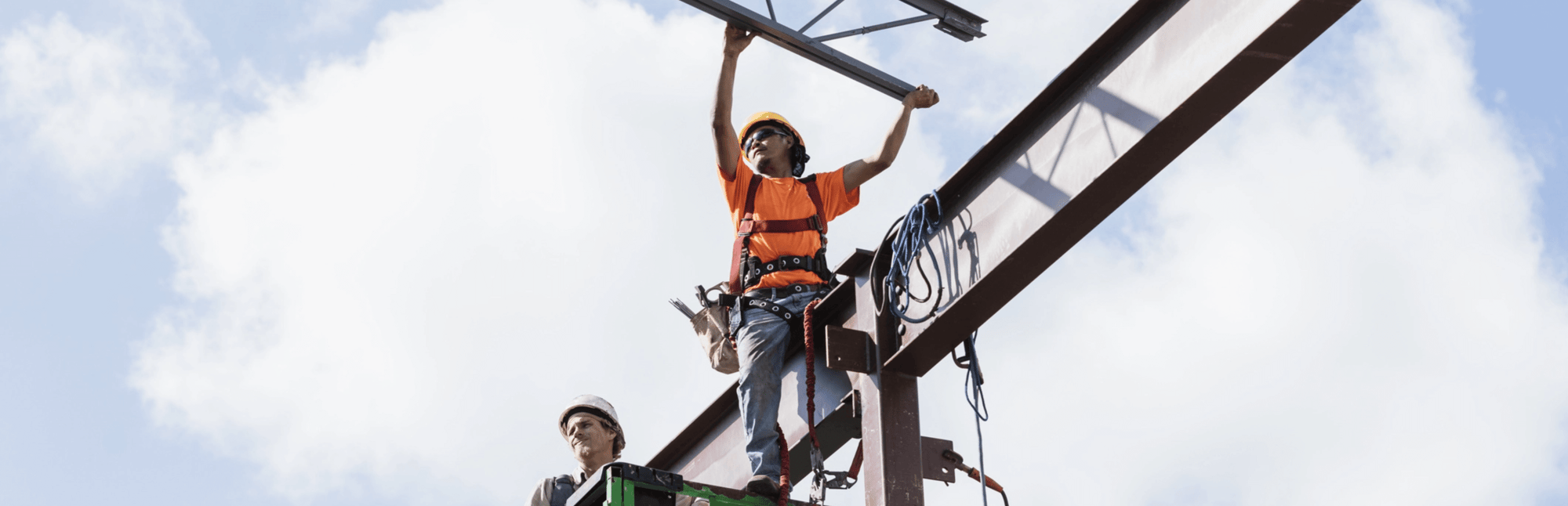 Construction worker with hands stretched out while on a beam