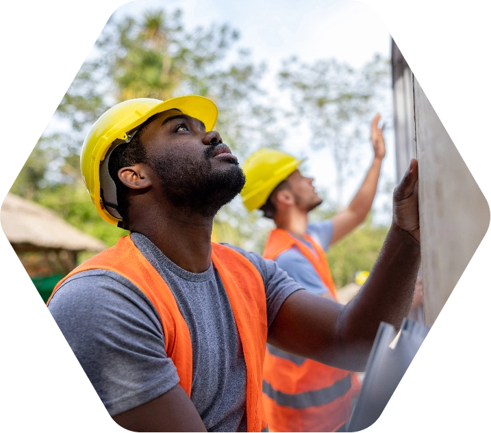 Two men in yellow hard hats at a construction site