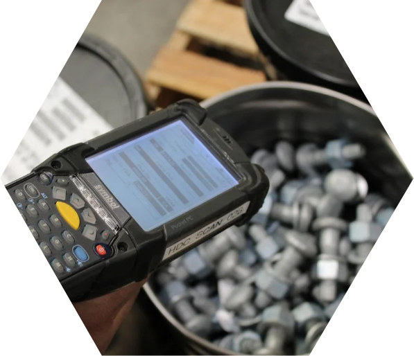 Handheld inventory scanner above a bin with bolts