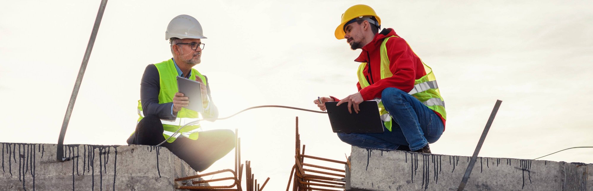 Two workers reviewing project details at a construction site