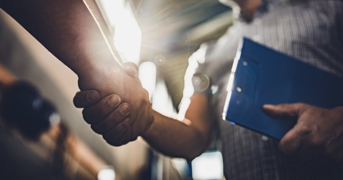 Two people shaking hands at a distribution center