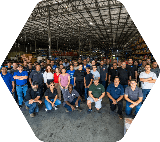 Team posing for a photo inside a warehouse